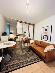 a living room with a brown couch and a table at New flat, best location Helsinki in Helsinki