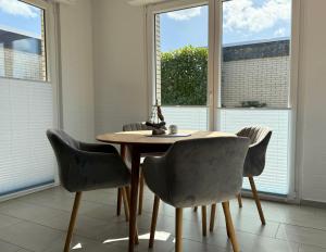 a dining room with a table and four chairs at Ferienhaus Wattglück Tossens in Butjadingen +7 photos