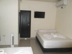 OritoHotel Monarca Putumayo的小房间设有两张床和电视 更多35张照片