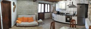 a kitchen with a couch with orange pillows on it at Casa Mitola in Congostro