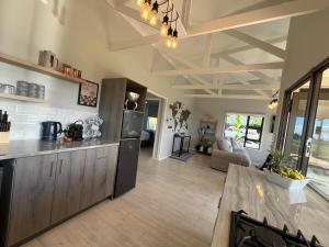 a kitchen and living room with a counter top at Elephant View Homestead - Hydrangea Cottage in Plettenberg Bay +32 photos