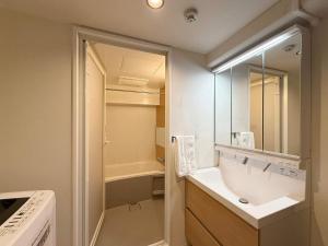 a bathroom with a sink and a mirror at Origaminn 702 by b hotel - 5 mins PeacePark in Hiroshima