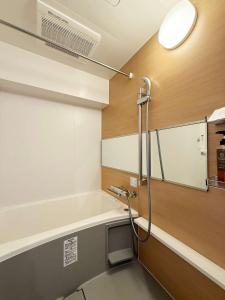 a bathroom with a shower with a sink and a mirror at Origaminn 702 by b hotel - 5 mins PeacePark in Hiroshima