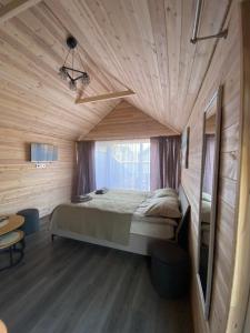 a bedroom with a bed in a wooden room at Trijų namelių uostas in Dreverna