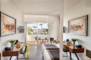 a living room with a bed and a dining room at Faros Hotel Ayia Napa in Ayia Napa
