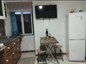 a kitchen with a small table and a refrigerator at Casa de Lá in São Roque do Pico