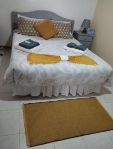 a bed with white sheets and brown pillows on it at Casa de Lá in São Roque do Pico