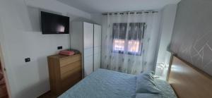 a small bedroom with a bed and a television at Enebrales Home in Punta Umbría +14 photos
