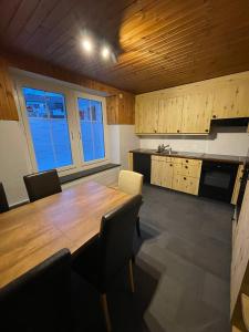 a large kitchen with a wooden table and chairs at vitalpha lodge - house in Glarus