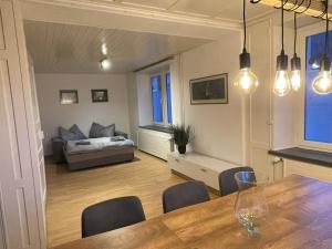 a living room with a dining room table and a bedroom at vitalpha lodge - house in Glarus
