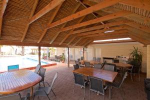a patio with tables and chairs and a pool at Bunbury Motel and Apartments in Bunbury