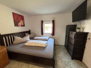 a bedroom with a bed with a dresser and a window at Jäger-Lodge in Lócs