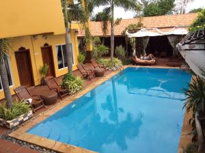 a large blue swimming pool next to a house at Ramchang Guesthouse in Battambang