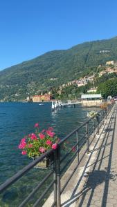 a balcony with flowers on the side of a body of water at Ninfea Como Lake - La casa del viandante in Bellano
