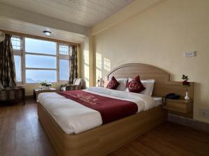 a bedroom with a large bed and a large window at New Amar Palace Shimla with Mountain View in Shimla