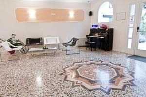 sala de estar con piano de cola y alfombra en Hotel Ai Dogi en Palmanova