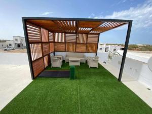 a pavilion on the roof of a building with green grass at Villa RAZAN in Midoun