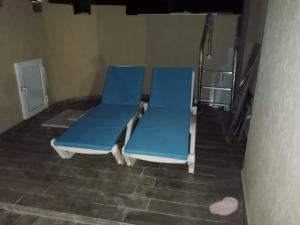 two blue chairs in a room with a staircase at Villa RAZAN in Midoun +3 photos