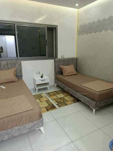 a room with two beds and a small table at Villa RAZAN in Midoun