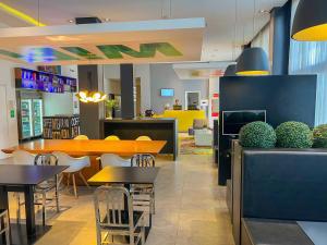 a restaurant with tables and chairs and a cafeteria at ibis Styles Rondonopolis in Rondonópolis