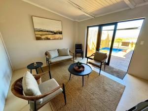 a living room with chairs and tables and a patio at Toorwater Spa in Uniondale