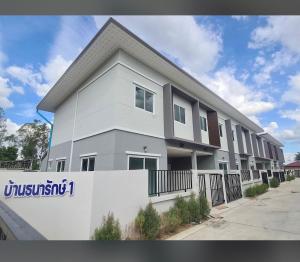 a white building with a sign in front of it at Baan Thanaluk 1 Pattaya in Pattaya +13 photos