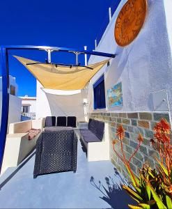 a patio with two chairs and a clock on a building at Milos village in Triovasálos