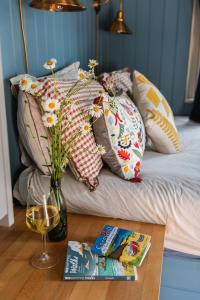 a vase of flowers on a table next to a bed at Peace in Piece in Redruth