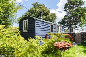 a blue tiny house with a bench in the yard at Peace in Piece in Redruth