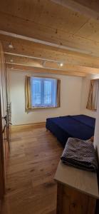 a room with two beds and a window at Chalet Wildi Horu OG in Niedergesteln