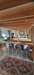 a living room with a table and chairs and a rug at Chalet Wildi Horu OG in Niedergesteln