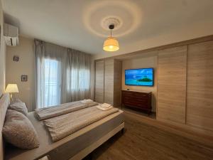 a bedroom with a bed and a flat screen tv at Casa de la Paz in Estepona