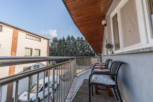 a balcony with two chairs and a car on it at Apartman Draga in Varaždin