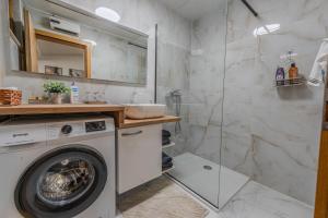 a bathroom with a washing machine and a shower at Apartman Draga in Varaždin +2 photos