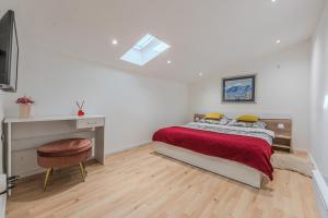 a white bedroom with a bed and a desk at Apartman Draga in Varaždin