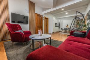 a living room with red chairs and a table at Apartman Draga in Varaždin
