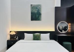 a bedroom with a large bed and a mirror at Cốm Homestay in Hue