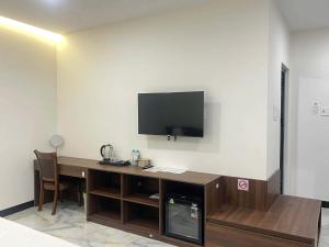 a room with a desk with a television on a wall at Khách Sạn Phượng Vĩ in Cà Mau