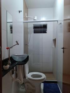 a bathroom with a toilet and a sink at Temporada Peterle | AP 101 Irirí in Anchieta