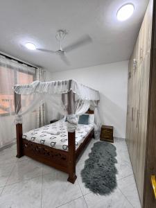 a bedroom with a bed with a canopy and a rug at Two bedroom, Nyali rd in Mombasa