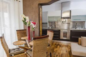 a dining room with a table and chairs and a kitchen at Central Blloku 2 bedroom Apartment in Tirana