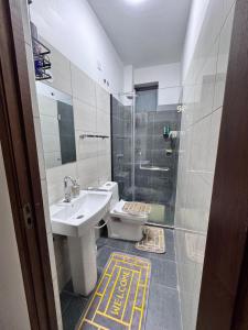 a bathroom with a toilet and a sink and a shower at Two bedroom, Nyali rd in Mombasa +23 photos