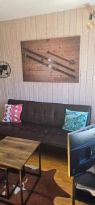 a living room with a brown couch and a table at Charmant petit appartement in Ovronnaz