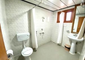 a bathroom with a toilet and a sink at sinchula Villa Resort in Paro +24 photos