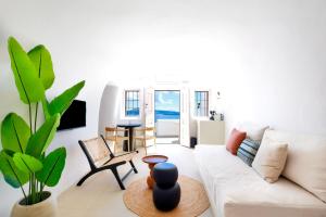 a living room with a white couch and a plant at You and Me Suites Oia in Oia