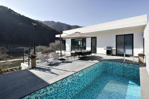 a house with a swimming pool next to a house at Be,Bridge Pool Villa Resort in Yeongwol