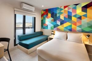 a hotel room with a bed and a colorful wall at Hotel101 - Madrid in Madrid