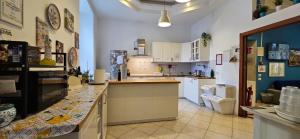 a kitchen with white cabinets and a counter top at Hostel Mancini Naples in Naples