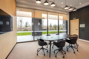 a dining room with a table and chairs and windows at Hotel101 - Madrid in Madrid