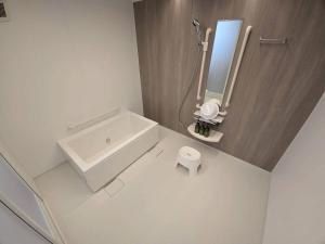 a white bathroom with a tub and a mirror at Tiz円居 in Minamiawaji +54 photos